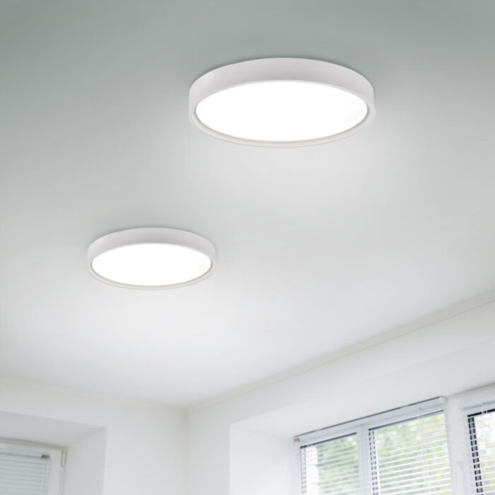 Suspended ceiling with modern LED lighting. Turned on lamps on the ceiling in office of white colours