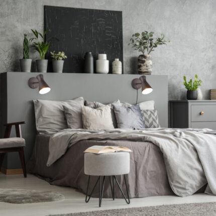 Stylish bedroom interior with bed with blankets and pillows, an